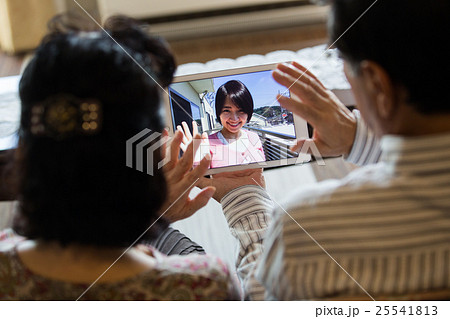 タブレットPCで孫とスカイプを楽しむ老夫婦 タブレットPCで孫とスカイプを楽しむ老夫婦 25541813