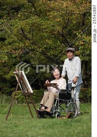 趣味の絵画を楽しむ車いすに乗った初老の妻と介助する夫 25541897