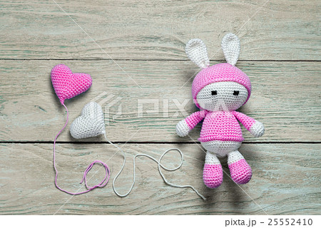 crochet bunny toy on a wooden background  25552410