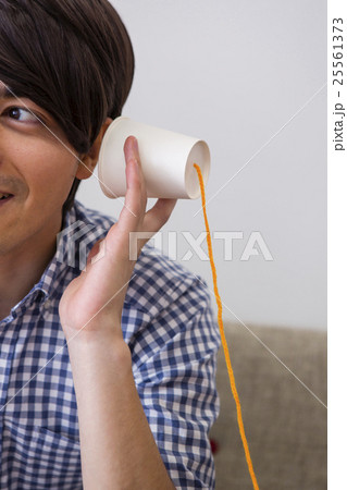 糸電話をする男性 25561373