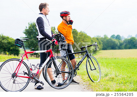 Two sport cyclists having break 25564205