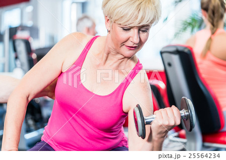 senior woman working out with dumbbells at the gym 25564234