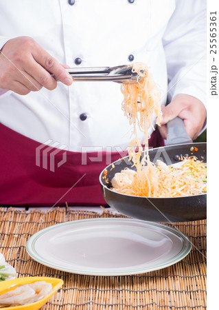 Chef fork over noodles by tongs Chef fork over noodles by tongs 25565361