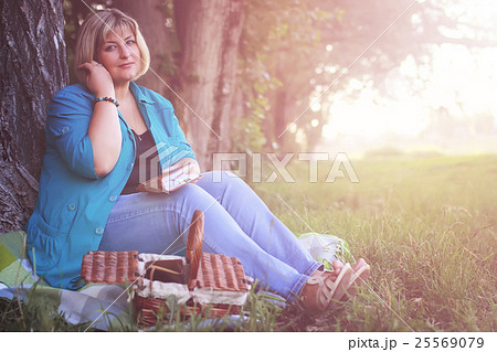 female in the park on sunset with book 25569079