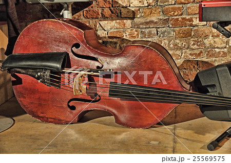 Contrabass on concert stage near old brick wall. 25569575