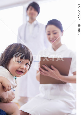 子供を診察する医者と看護士 子供を診察する医者と看護士 25572154