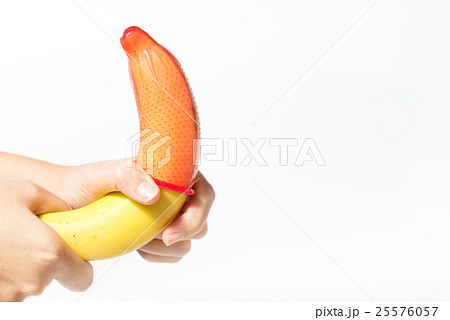 Female hand puts on a condom onto a banana 25576057