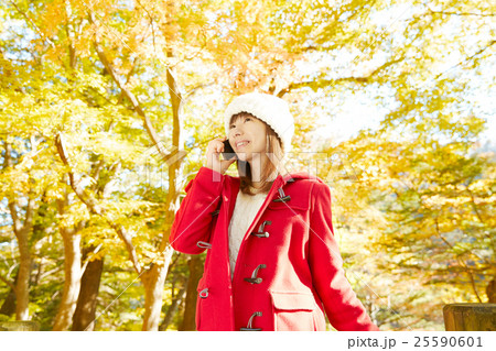 スマートフォンで話す女性　紅葉背景 25590601
