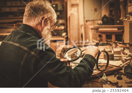 Senior restorer working with antique decor element Senior restorer working with antique decor element 25592404