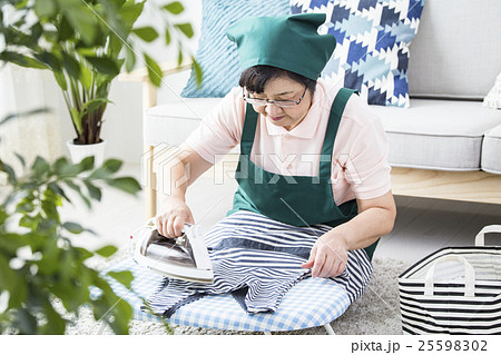 アイロンをかけるシニアハウスキーパー 25598302