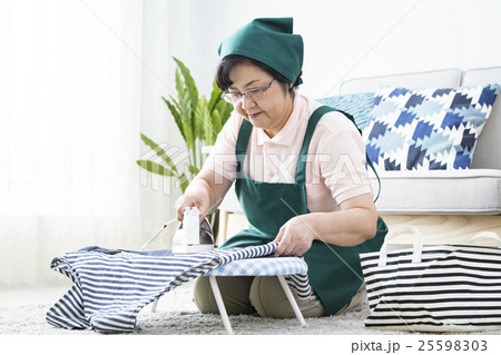 アイロンをかけるシニアハウスキーパー 25598303