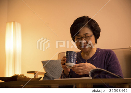 夜に雑誌を読むシニア女性 25598442