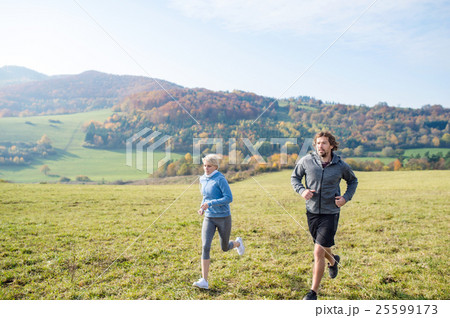 Beautiful young couple running in sunny autumn Beautiful young couple running in sunny autumn 25599173