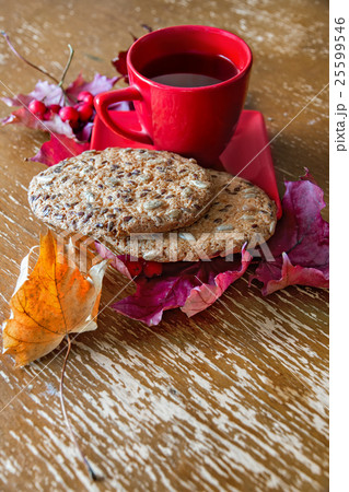 Red Cup with cookies, autumn leaves and berries Red Cup with cookies, autumn leaves and berries 25599546