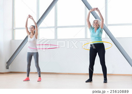 Persistent positive women exercising with hula Persistent positive women exercising with hula 25610889