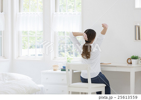 女性 後ろ姿 座るの写真素材