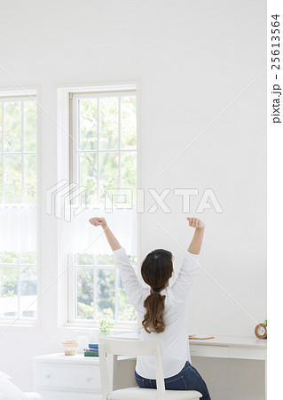 女性 後ろ姿 座るの写真素材