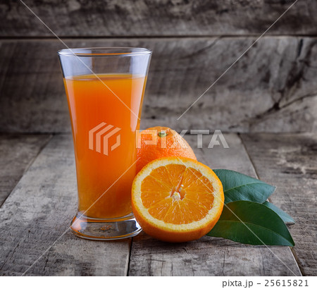 Orange juice glass and fresh oranges on wood 25615821