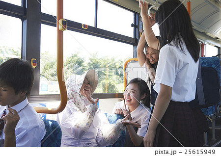 バス車内 おばあちゃんと会話する女子中高生の写真素材