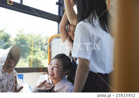バス車内 おばあちゃんと会話する女子中高生の写真素材
