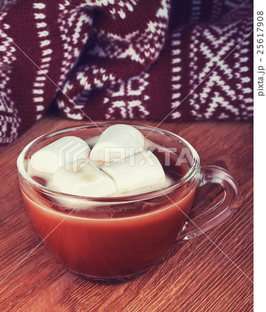 cup of cocoa with marshmallow and scarf on wood 25617908
