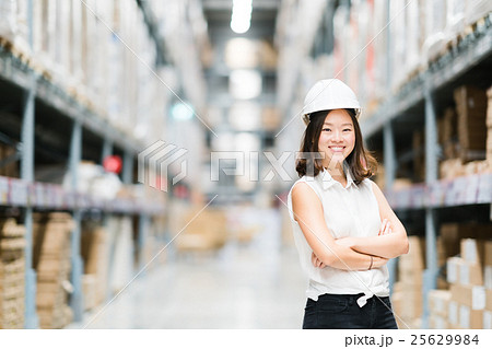 Cute Asian engineer smiling, warehouse background 25629984