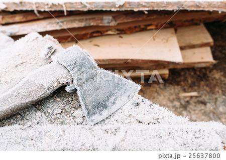 Big axe outside near bunch of firewood 25637800