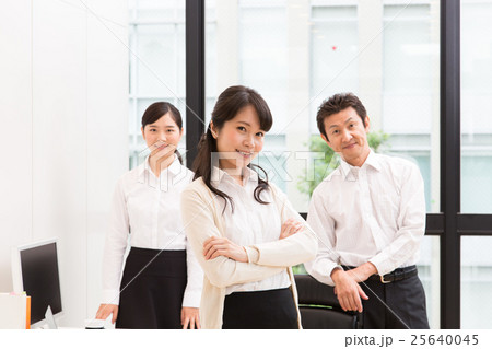 オフィスで腕組みをする女性とグループワーカー オフィスで腕組みをする女性とグループワーカー 25640045