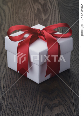 gift box with red bow on rustic table 25640462
