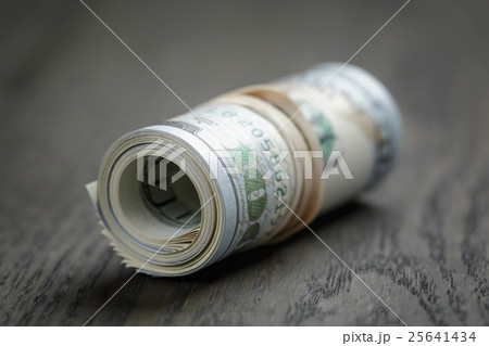 roll of new style hundred dollar bills on table roll of new style hundred dollar bills on table 25641434