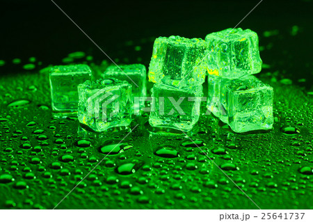 ice cubes on lighting green background. 25641737