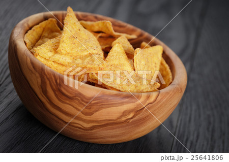tortilla chips in olive wood bowl on wooden table 25641806