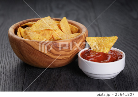 tortilla chips in olive wood bowl on wooden table 25641807