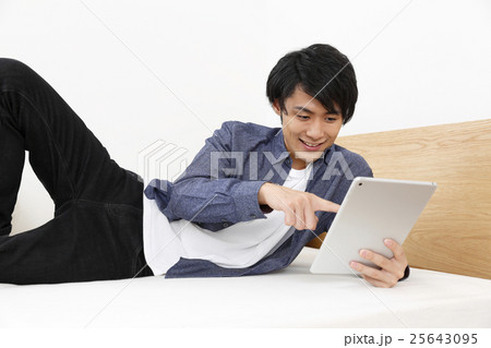 タブレットを使う若い男性 25643095