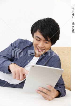 タブレットを使う若い男性 25643096