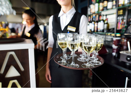 Waitress with dish of champagne and wine glasses 25643627