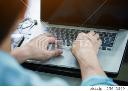 Asian man using laptop on a desk in the morning 25643849