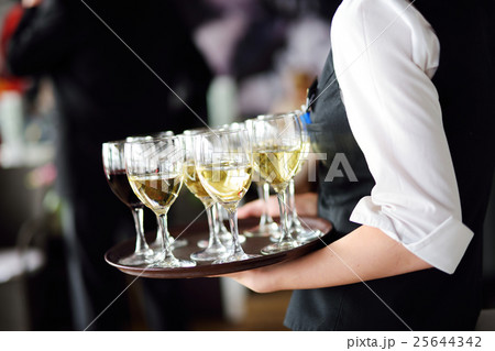Waitress with dish of champagne and wine glasses 25644342