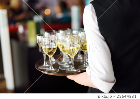 Waitress with dish of champagne and wine glasses 25644831