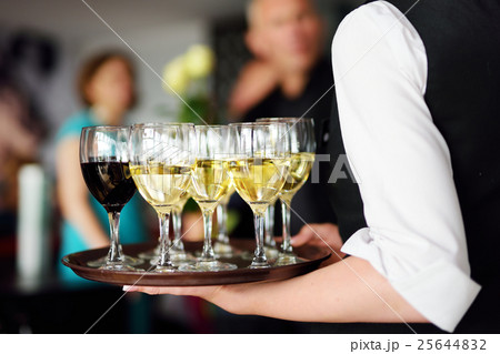 Waitress with dish of champagne and wine glasses 25644832