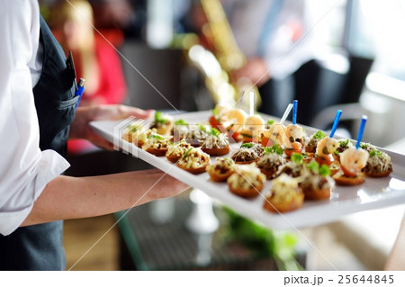 Waiter carrying plates with meat dish 25644845