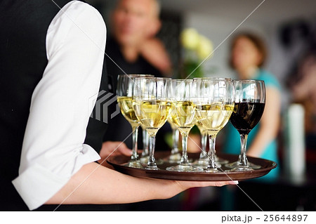 Waitress with dish of champagne and wine glasses 25644897