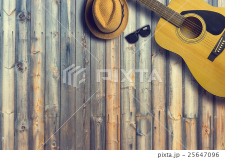 Acoustic guitar with hat and sunglasses on wooden Acoustic guitar with hat and sunglasses on wooden 25647096