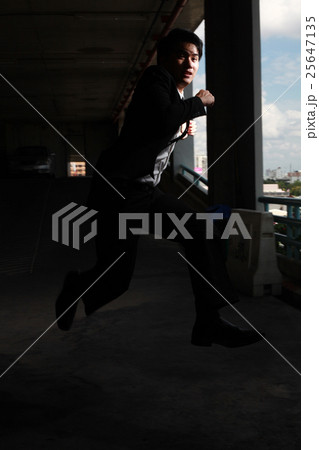 Happy young handsome businessman in formalwear running in parkin 25647135