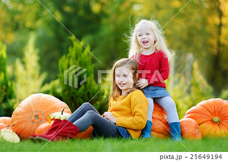 Two little sisters playing with huge pumpkins 25649194