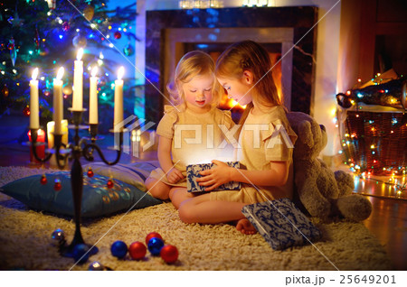 Adorable little girls opening a magical Christmas gift 25649201