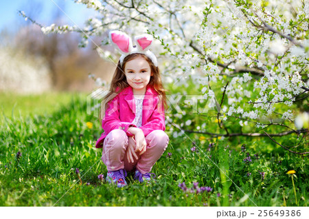 Adorable little girl in blooming cherry garden Adorable little girl in blooming cherry garden 25649386