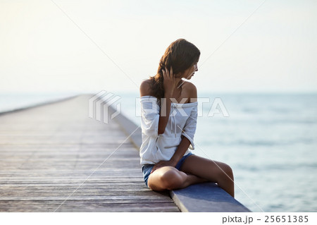 Young beautiful woman sitting on the pier Young beautiful woman sitting on the pier 25651385