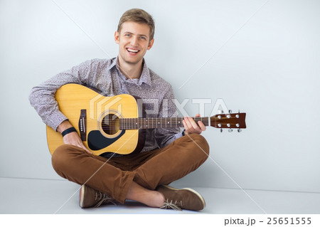 Portrait of happy handsome man playing guitar 25651555
