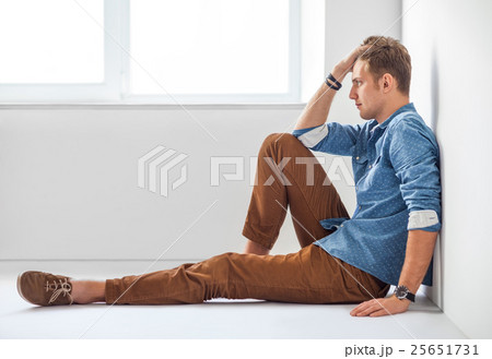 Portrait of tired handsome man sitting on the floor 25651731
